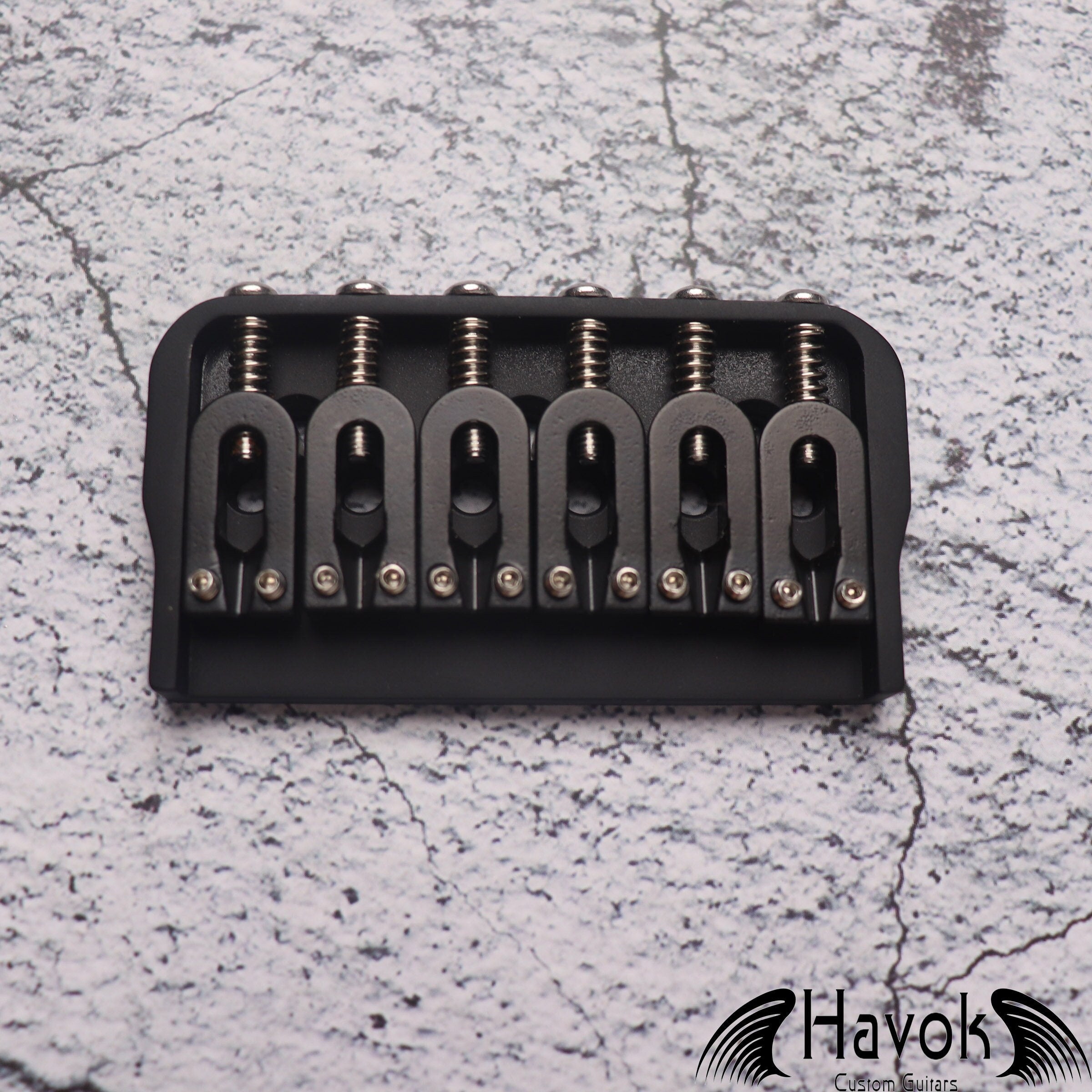 A low profile Hard Tail Bridge in black color. It's made from stainless steel and has very high quality for guitar building.