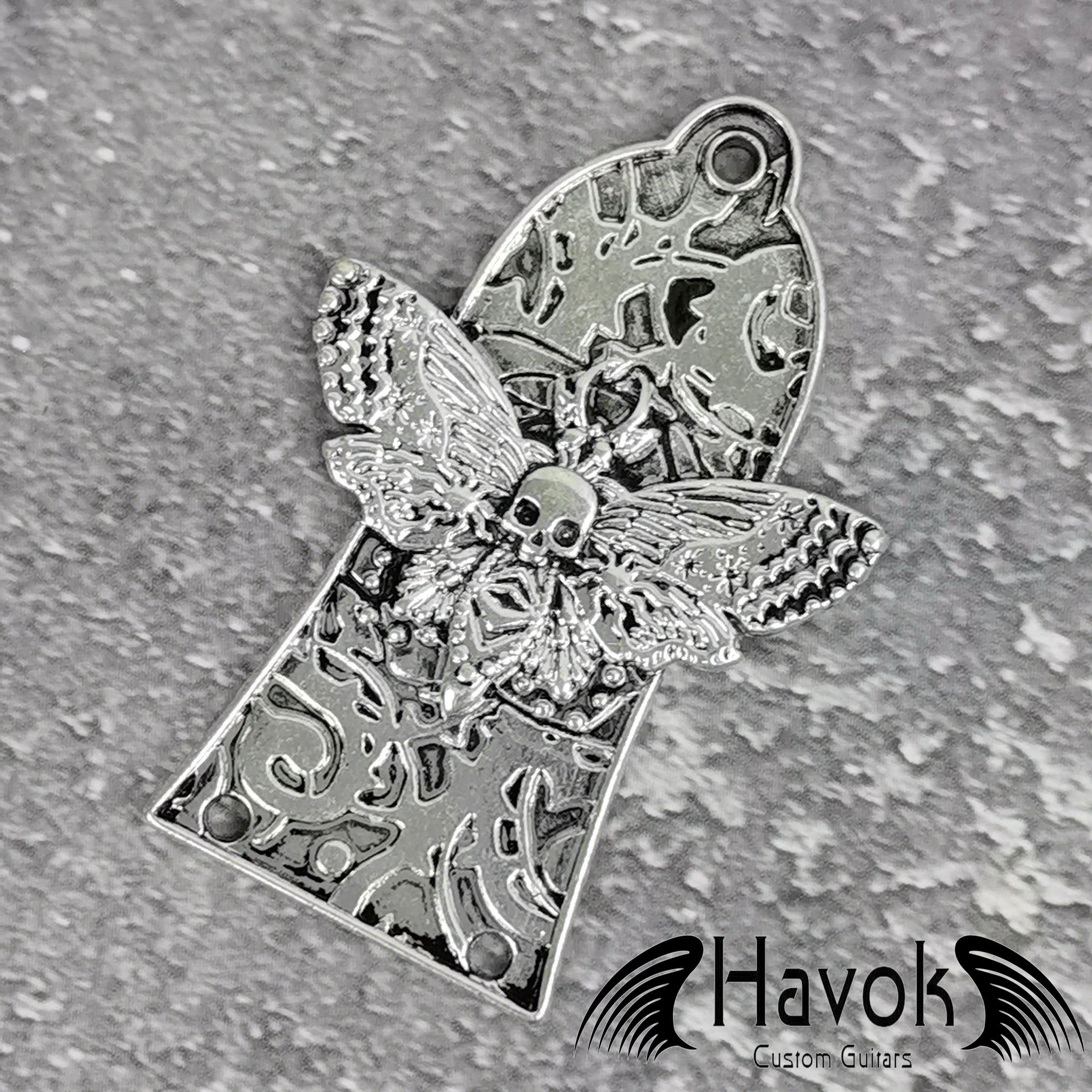 A vintage style metal truss rod plate for electric guitars. It comes in unique design of skeleton moth. The color is silver.
