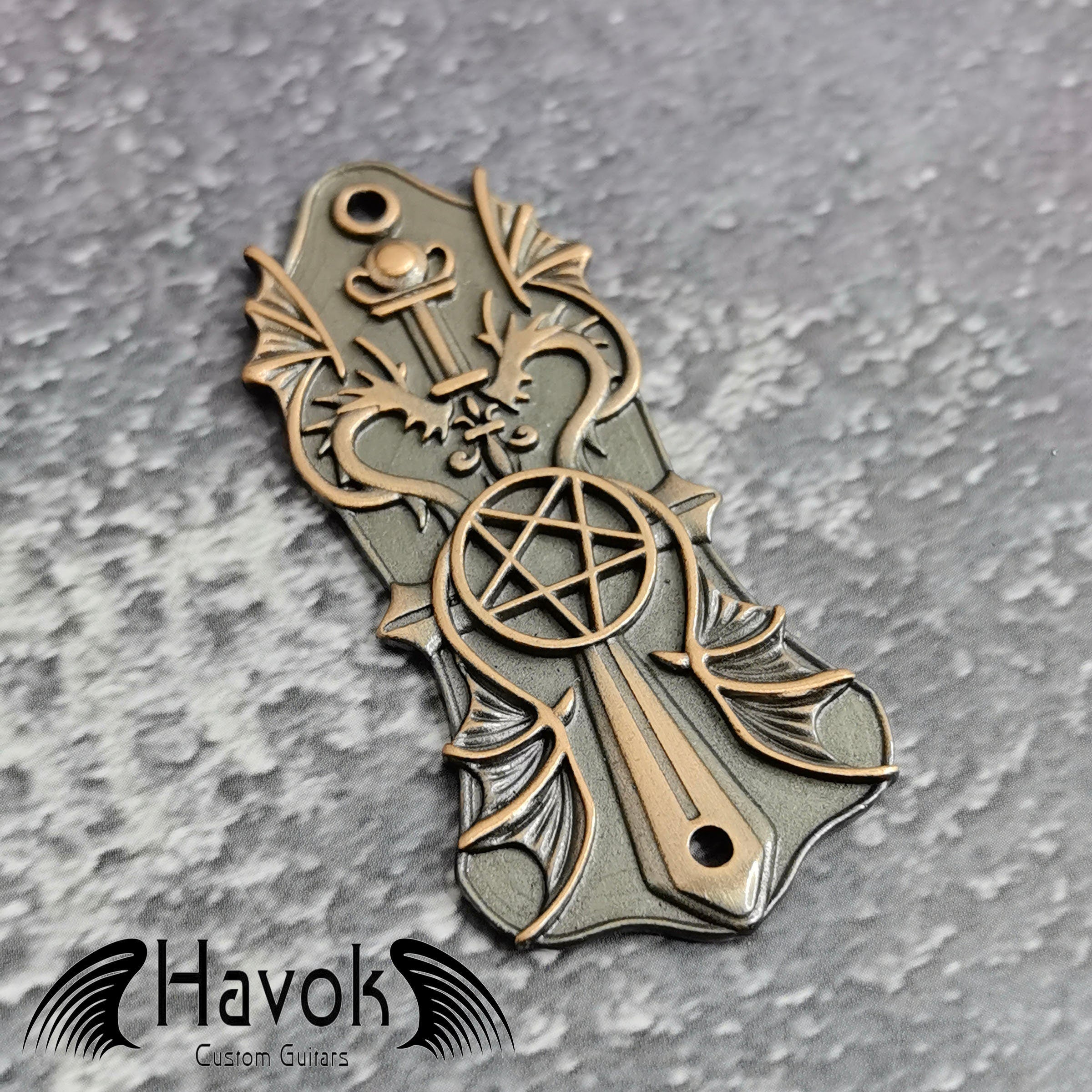 A vintage style metal truss rod plate for electric guitars. It comes in unique design of pentagram and two dragons. The color is brass.
