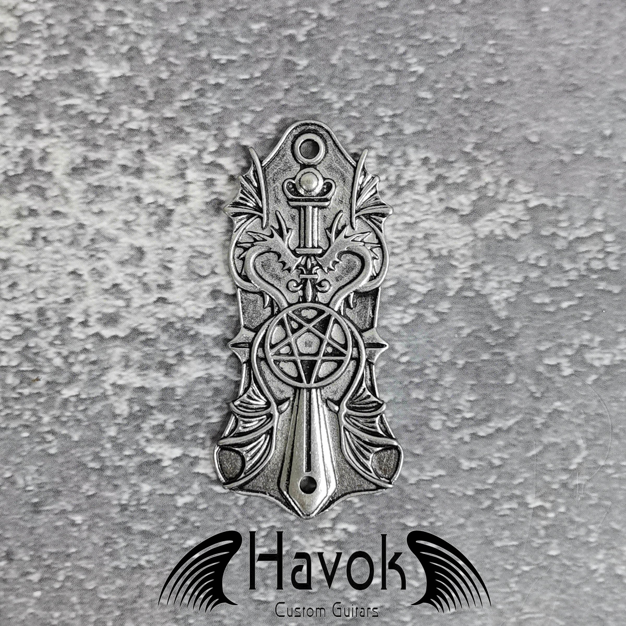 A vintage style metal truss rod plate for electric guitars. It comes in unique design of pentagram and two dragons. The color is silver.