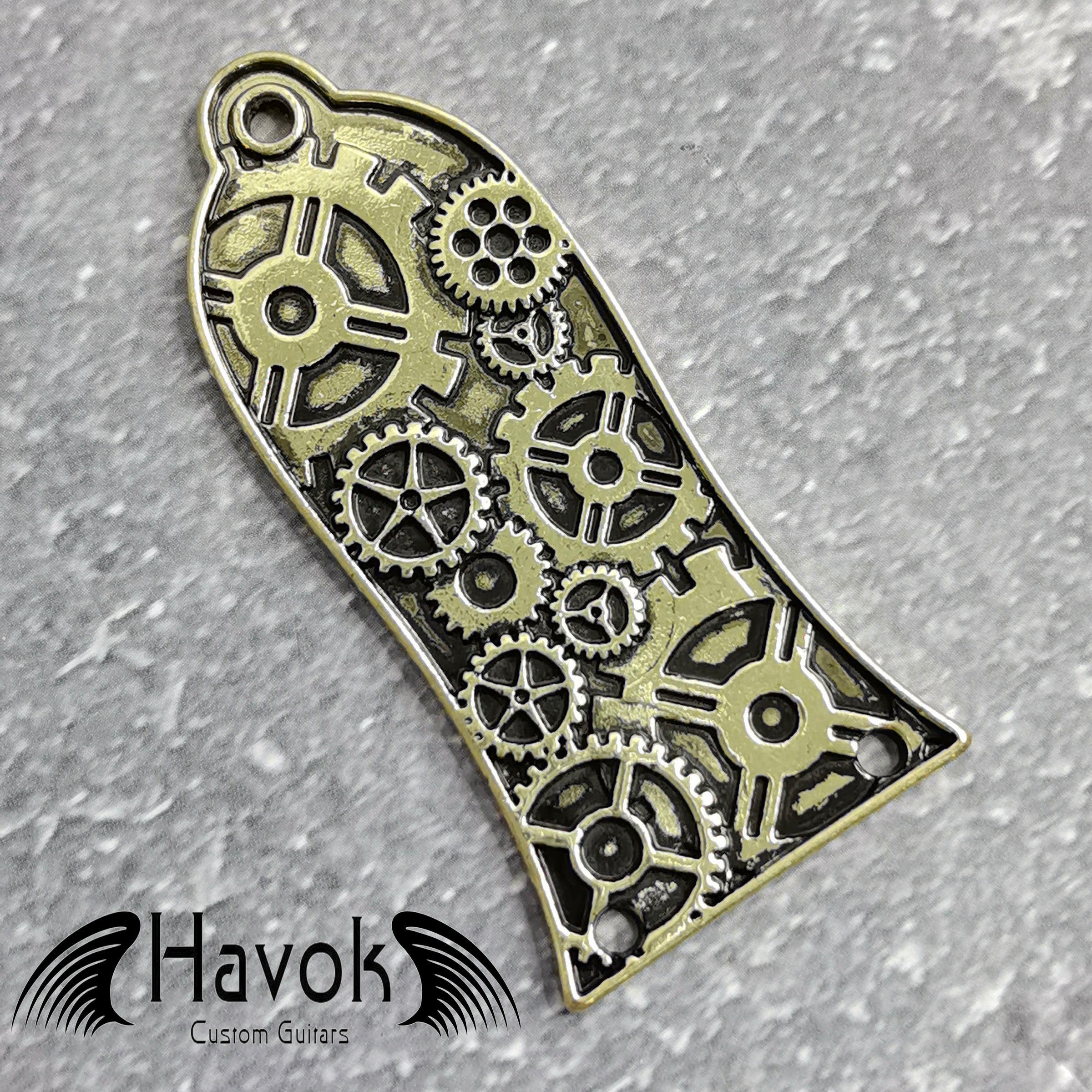 A vintage style metal truss rod plate for electric guitars. It comes in unique design of cogwheels. The color is brass.